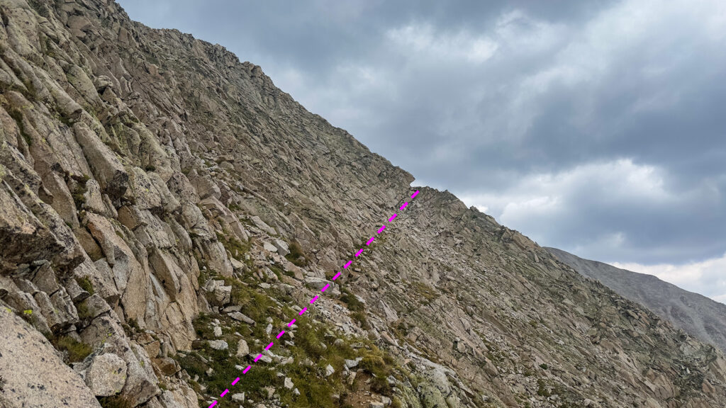 Aim for a notch in slope that the grassy ledges conveniently lead you to. Travel through the notch.